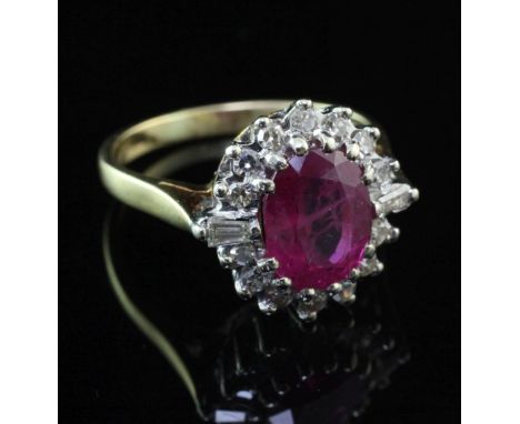 An 18ct gold, ruby and diamond oval cluster ring, the oval cut ruby weighing approximately 1.50-2.00ct and bordered by round 