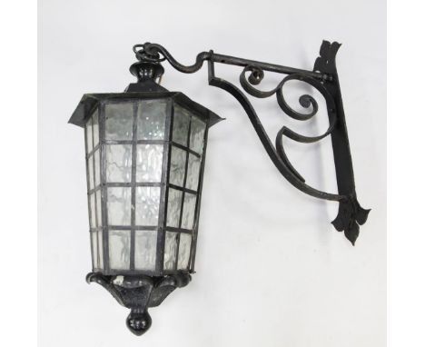 A large black painted hexagonal tapering lantern, with glass panels, and wrought iron hanging bracket, drop 3ft 4in. incl. ha