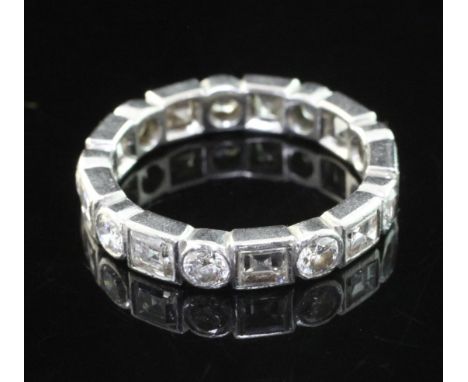 A 20th century platinum and diamond full eternity ring, set with alternating round brilliant and square cut diamonds, size M.