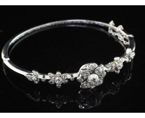 An early 20th century white gold and diamond hinged bangle, with five foliate motifs set with old and rose cut diamonds, with