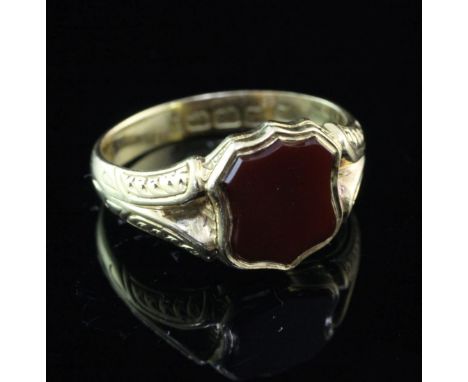 A late Victorian 18ct gold and carnelian set signet ring, with shield shaped stone and engraved shoulders, size P.