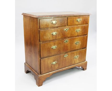 A George II walnut and featherbanded chest, of two short and three long graduated drawers with brass handles, on bracket feet