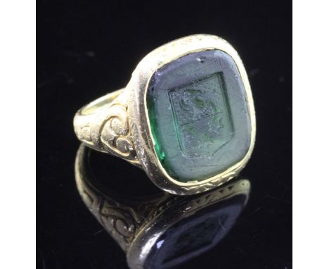 An antique style continental 18k gold and green tourmaline intaglio ring, with carved matrix depicting a ram's head above thr