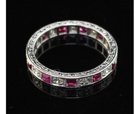 An 18ct white gold, ruby and diamond full eternity ring, set with eleven rubies with an estimated total weight of 1.20ct, siz