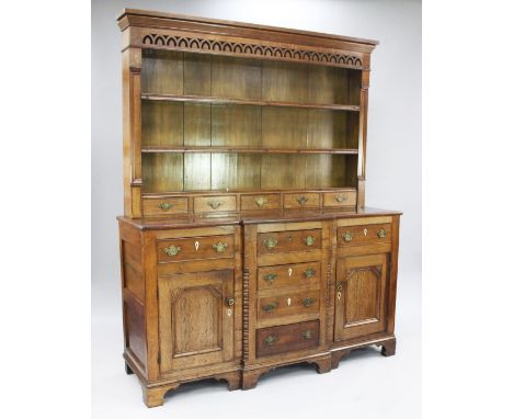 A George III oak Welsh dresser, the plate rack with pierced arched frieze, two fitted shelves and five base drawers above a c