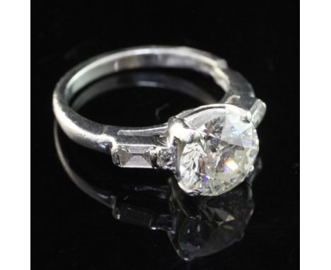 A 20th century platinum and single stone diamond ring, with baguette and diamond chip set shoulders, the central stone with t