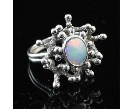 A 1970's 9ct white gold and white opal set free form ring by John Donald, with central oval stone, size N.