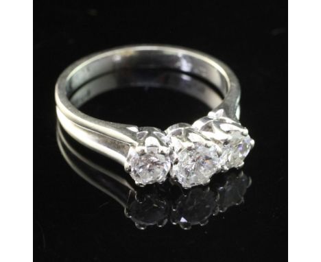 A modern 18ct white gold and three stone diamond ring, the round brilliant cut stones with an approximate total weight of 0.8