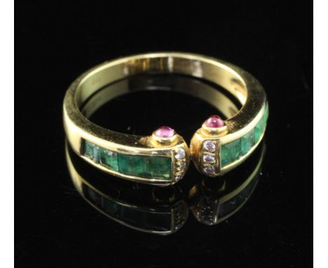 A stylish 18ct gold, emerald and diamond ring, with cabochon ruby set terminals, size O.