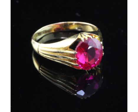 An early/mid 20th century gold and solitaire synthetic ruby claw set ring, with fluted shoulders, size S.