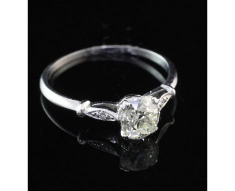 A platinum and single stone diamond ring, with diamond set shoulders, the central shapeed oval old cut stone weighing approxi
