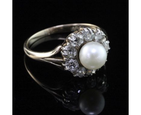 An early 20th century 15ct gold cultured pearl and diamond cluster ring, size M.