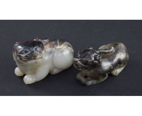 Two Chinese jade figures of mythical beasts, 18th/19th century, the first a recumbent lion-dog in greyish white and brown jad