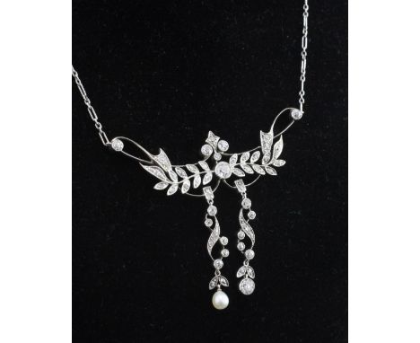 An early 20th century gold, diamond and pearl double drop pendant necklace, of foliate design, set with old cut diamonds with
