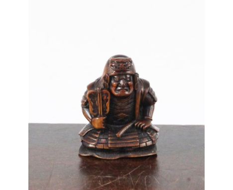 A Japanese boxwood netsuke of a seated Samurai General, late 19th century, engraved two character signature, the seated Gener