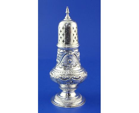 A late Victorian repousse silver sugar caster, with foliate scroll decoration and turned finial, Josiah Williams & Co, London