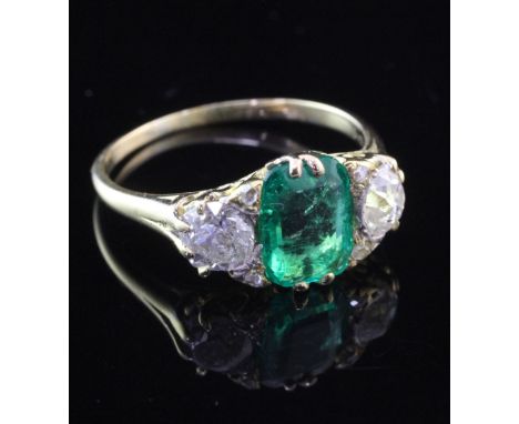 A Victorian style 18ct gold, three stone emerald and diamond ring, the central emerald weighing approximately 1.72ct and flan