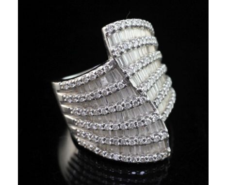 A stylish modern 18ct white gold and diamond encrusted dress ring, set with round brilliant and baguette cut stones, size P.