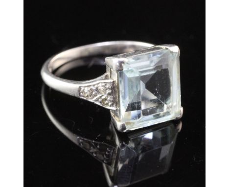 A mid 20th century platinum, aquamarine and diamond ring, with emerald cut aquamarine and diamond set shoulders, size J.