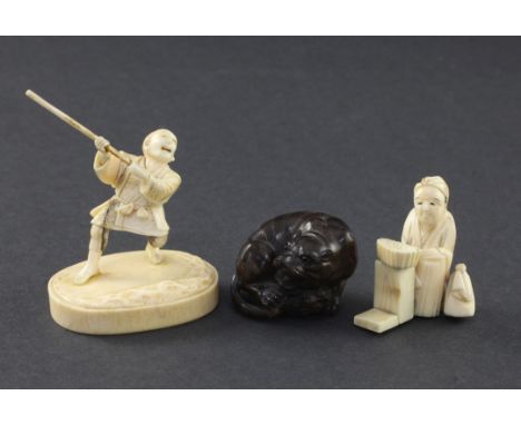 Two Japanese ivory okimono and a wood netsuke, the first ivory okimono of a warrior holding a star, engraved two character si