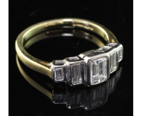 An 18ct gold and collet set graduated emerald cut diamond half hoop ring, size O.