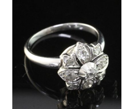 An early 20th century white gold and diamond cluster ring, of flower head design, set with old and rose cut diamonds, size M.
