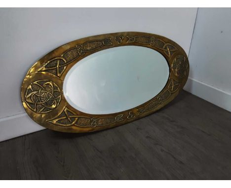 ARTS &amp; CRAFTS BRASS MIRROR,the oval frame embossed with Celtic knotwork, bevelled plate, 41cm x 85cm