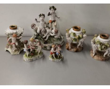 A Capodimonte porcelain group of five puttis, together with three German porcelain oil lamp bases and two porcelain putti gro