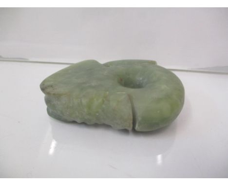 A carved green jade coloured ornament decorated with a headLocation: CAB 