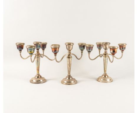 A GARNITURE OF THREE SILVER TABLE CANDELABRA (3)Comprising; a pair of five light and one three light, each with reeded arms, 