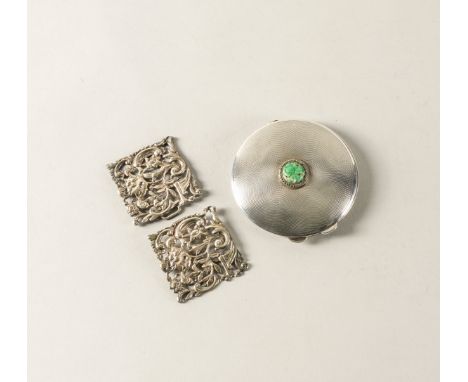 A SILVER POWDER COMPACT AND A SILVER TWO PIECE BUCKLE (2)The circular compact mounted with a circular carved jade at the cent