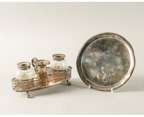 A PLATED INKSTAND AND A SILVER WAITER (2)The oval inkstand decorated with pierced galleries, fitted with two faceted glass in