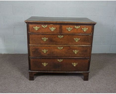 A Queen Anne oak chest of drawers, circa 1710, with a rectangular plain top with feather banding, over two short and three lo