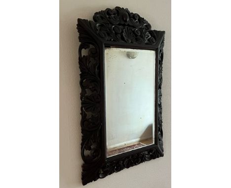 A hardwood Chinese ornate mirror with foliate design (65cm x 94cm)