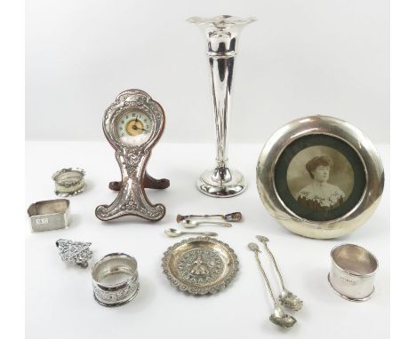 A silver spill vase, of usual form, 24.5cm high; a silver fronted mantel clock, Chester 1910; a round silver fronted photo fr