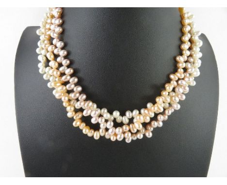 A three strand cultured freshwater pearl necklace, three colour (stained peach and pink rows), top drilled, the clasp marked 