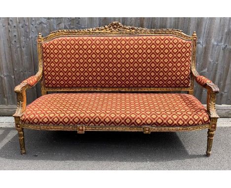A 19th century gild wood sofa, the top rail and arms carved with leafs, upholstered in a red fabric, 112cm high, 163cm long, 