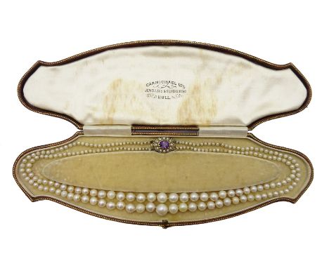  Two row graduating pearl necklace, with 9ct gold amethyst and split seed pearl clasp, retailed by Carmichael Ltd, Hull, in o