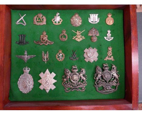 A GLAZED DISPLAY CASE CONTAINING TWENTY TWO BRITISH ARMY CAP BADGES, 34 CM X 41 CM 