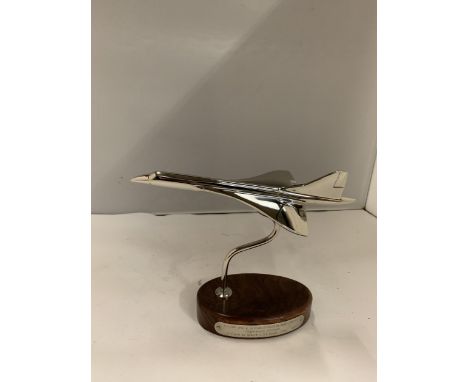 A CHROME MODEL OF CONCORDE ON A WOODEN PLINTH HEIGHT 17CM 