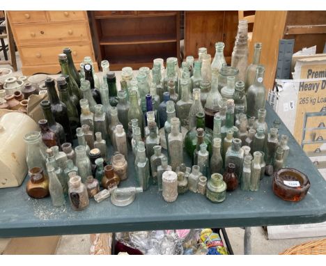 A LARGE QUANTITY OF GREEN, BLUE, BROWN AND CLEAR VINTAGE GLASS BOTTLES 