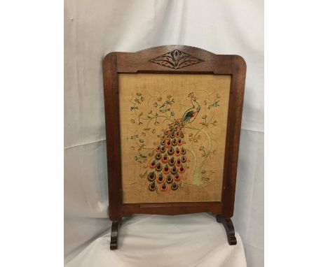 A WOODEN FRAMED FIRESCREEN WITH A TAPESTRY OF A PEACOCK 