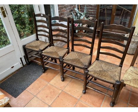 A SET OF FOUR LANCASHIRE STYLE OAK LADDER BACK DINING CHAIRS WITH RUSH SEATS 