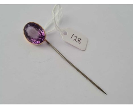 A large amethyst stick pin mount set in gold and metal pin