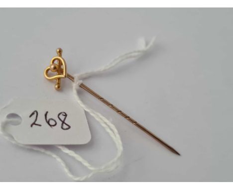 A Victorian lover’s heart and bow stick pin set in gold