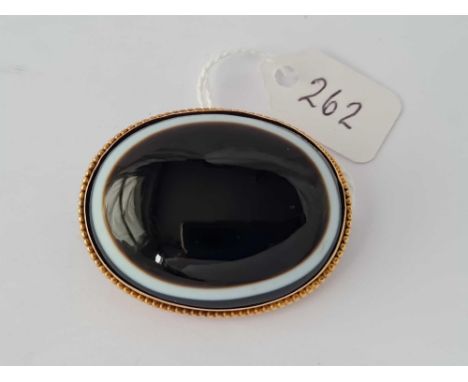 A very fine quality Victorian black enamel brooch with the centre banded onyx agate in high carat gold, having a full hair gl