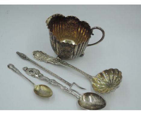 A small Victorian silver cream jug having engraved floral and scallop shell decorative panels interspersed by gadrooned panel