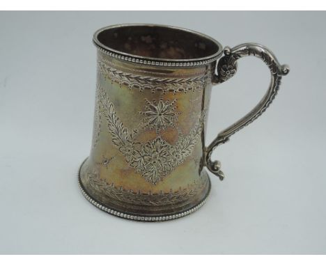 A Victorian silver Christening mug of tapered form having engraved floral swag decoration and monogrammed cartouche with gadr