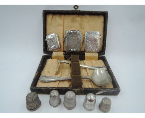 A small selection of HM silver including three vestas, a cased baby's first cutlery set, and five HM silver and white metal t