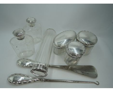 Six glass dressing table pots and bottles  of assorted shapes having HM silver lids, and a matching silver handled button hoo